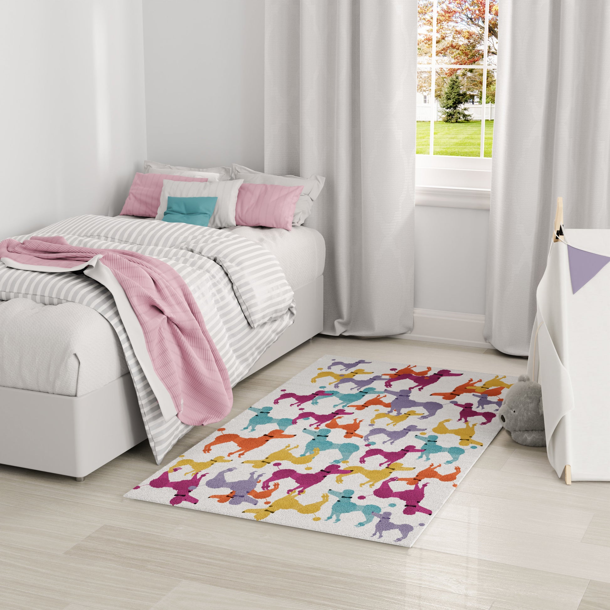 Kids' bedroom rug featuring multicolor dancing silhouettes on a light background, beside a white bed with pink throw and gray-striped bedding.