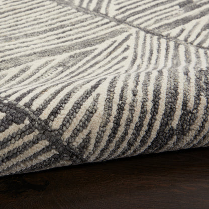 Close-up of a plush cream and charcoal gray striped area rug with a thick pile on a dark wood floor.