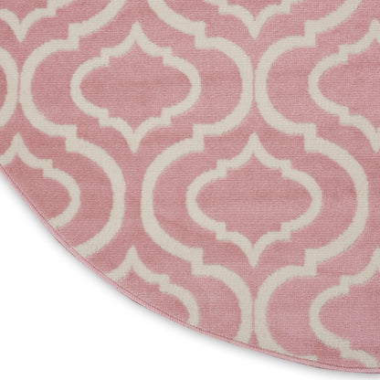 Round pink rug with white Moroccan trellis pattern.