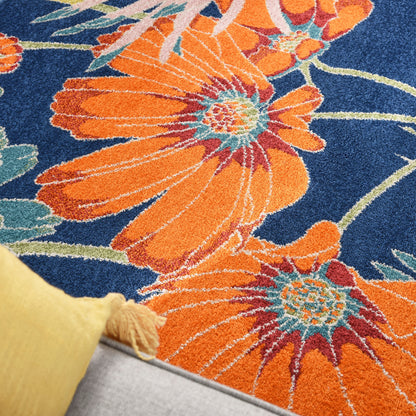 Plush orange floral rug with large blossoms on navy blue ground; teal centers; cozy living room decor.
