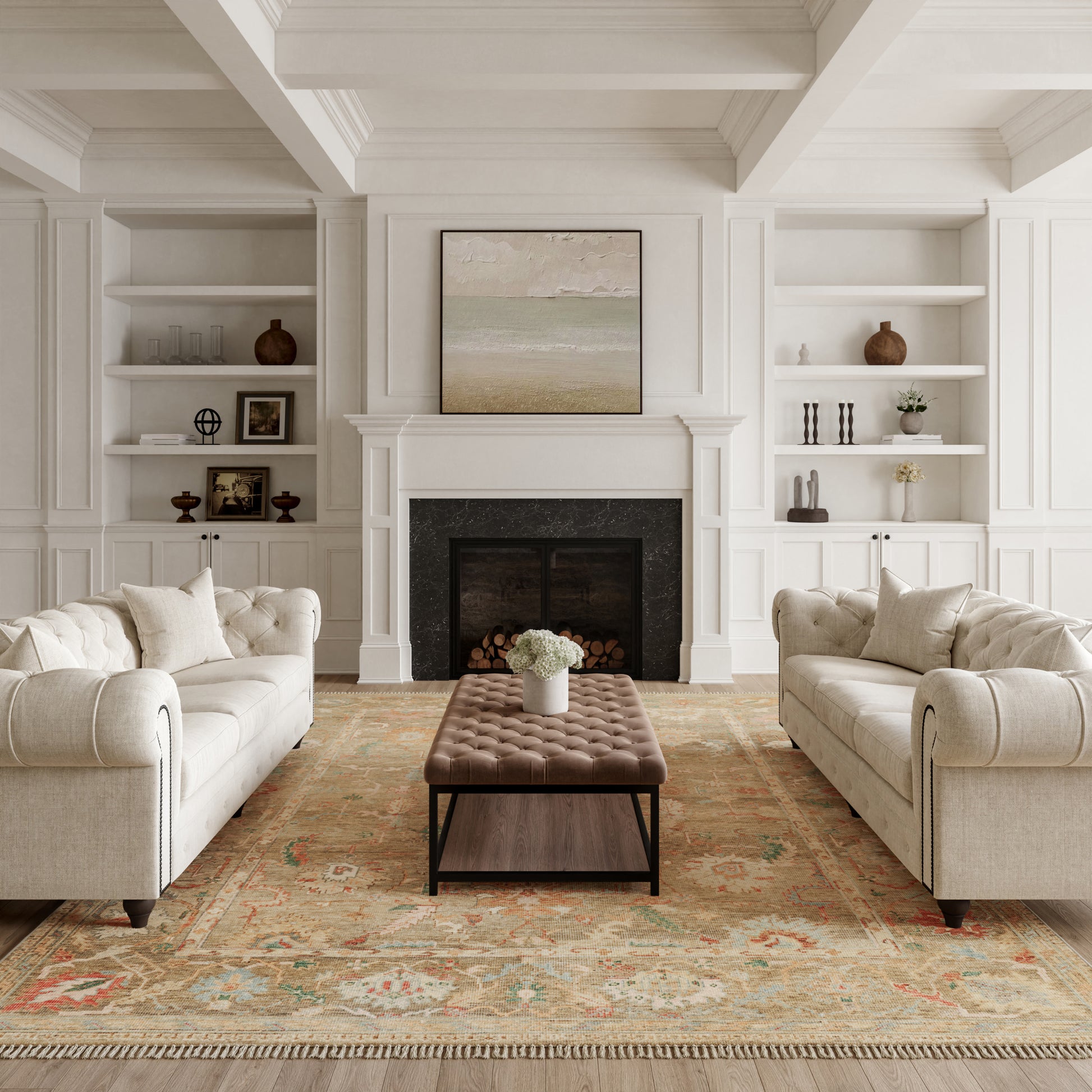 Cream tufted sofas face a black fireplace with a brown tufted ottoman, white paneled walls, built-in shelves, and a warm rug.