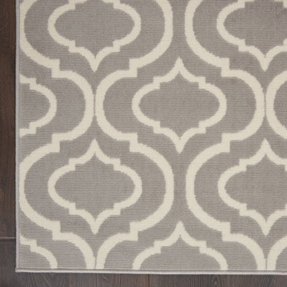 Gray flat-weave rug with white interlocking trellis pattern; rectangular, modern geometric decor.