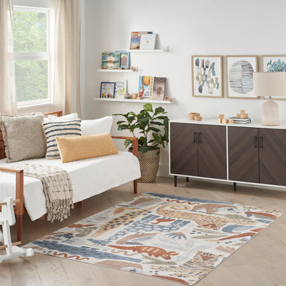 Boho living room with pale wood floor, colorful geometric rug, white sofa, striped pillow, and dark wood sideboard.