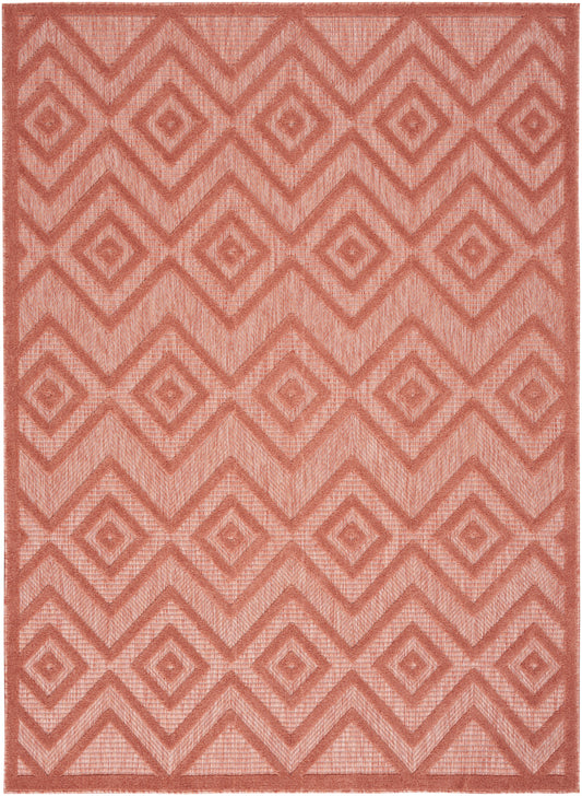 Coral red geometric rug with nested diamond and chevron pattern; woven textured rectangular area rug.