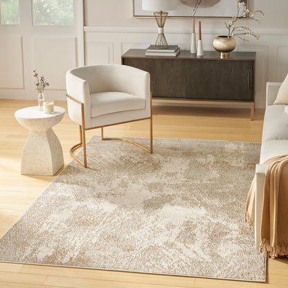 Beige abstract area rug 5' x 7' with a cream upholstered accent chair with gold metal legs & a speckled stone side table resting on it.
