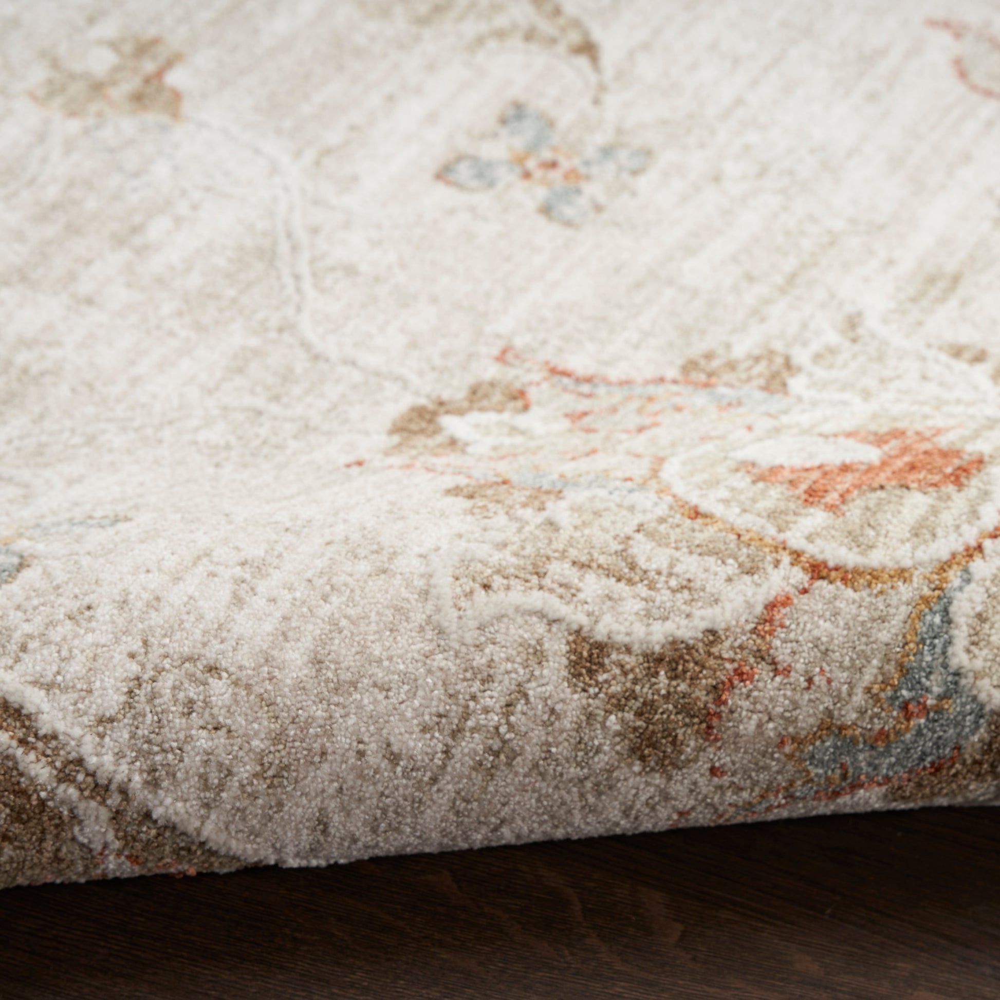 Cream plush vintage 10' runner rug with subtle pastel motifs and high pile on a dark wood floor.