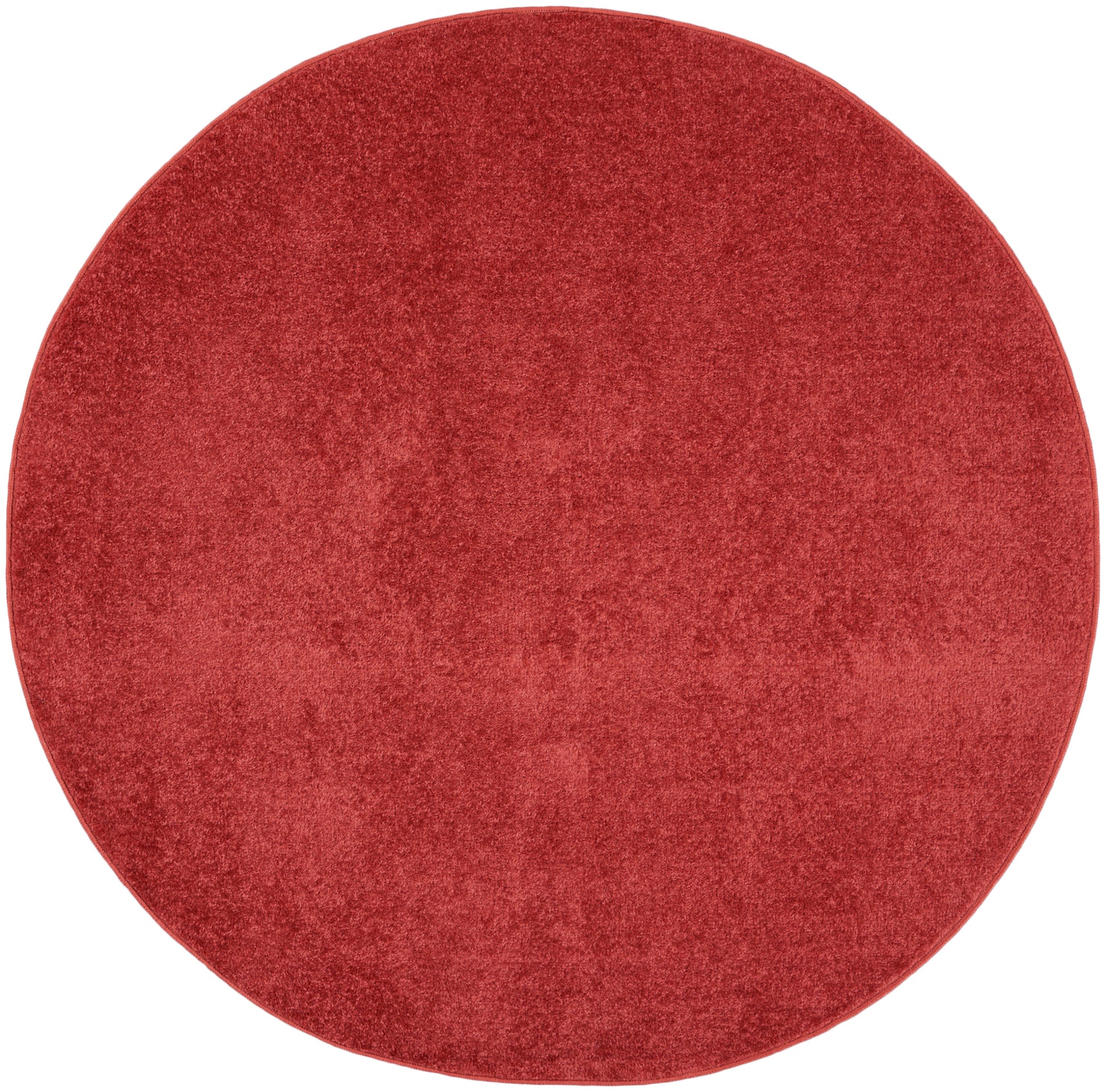 Round red plush rug with velvety texture for cozy living spaces.