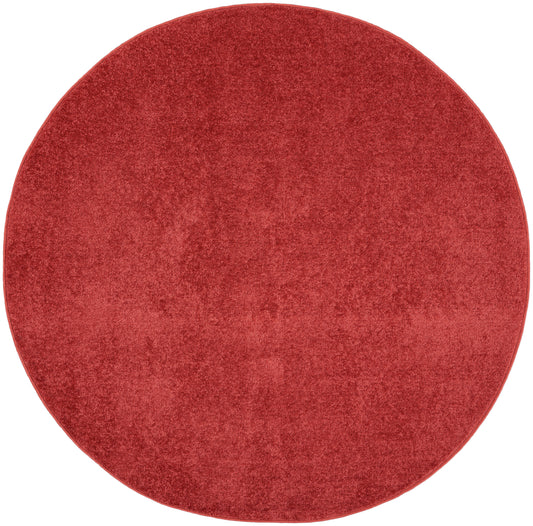 Round red plush rug with velvety texture for cozy living spaces.