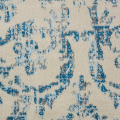 Beige woven fabric with blue damask scroll pattern; elegant upholstery or curtain textile.