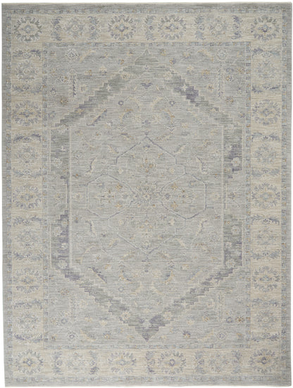 Soft gray-blue and beige oriental area rug with a faded central medallion and floral border.