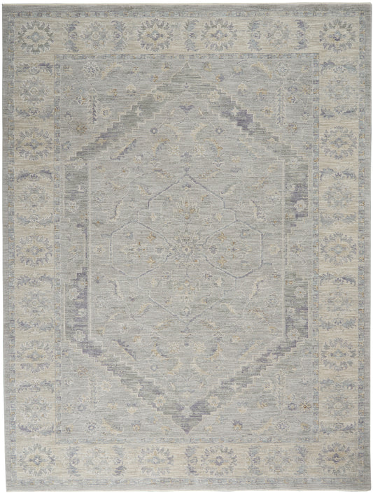 Soft gray-blue and beige oriental area rug with a faded central medallion and floral border.