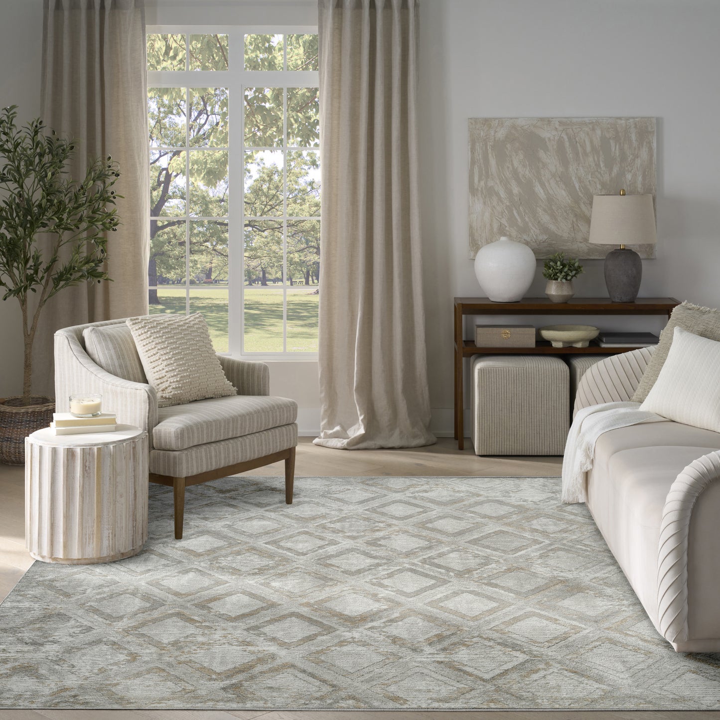 Neutral living room with striped beige armchair, round ribbed side table, beige curtains, and a gray patterned rug.