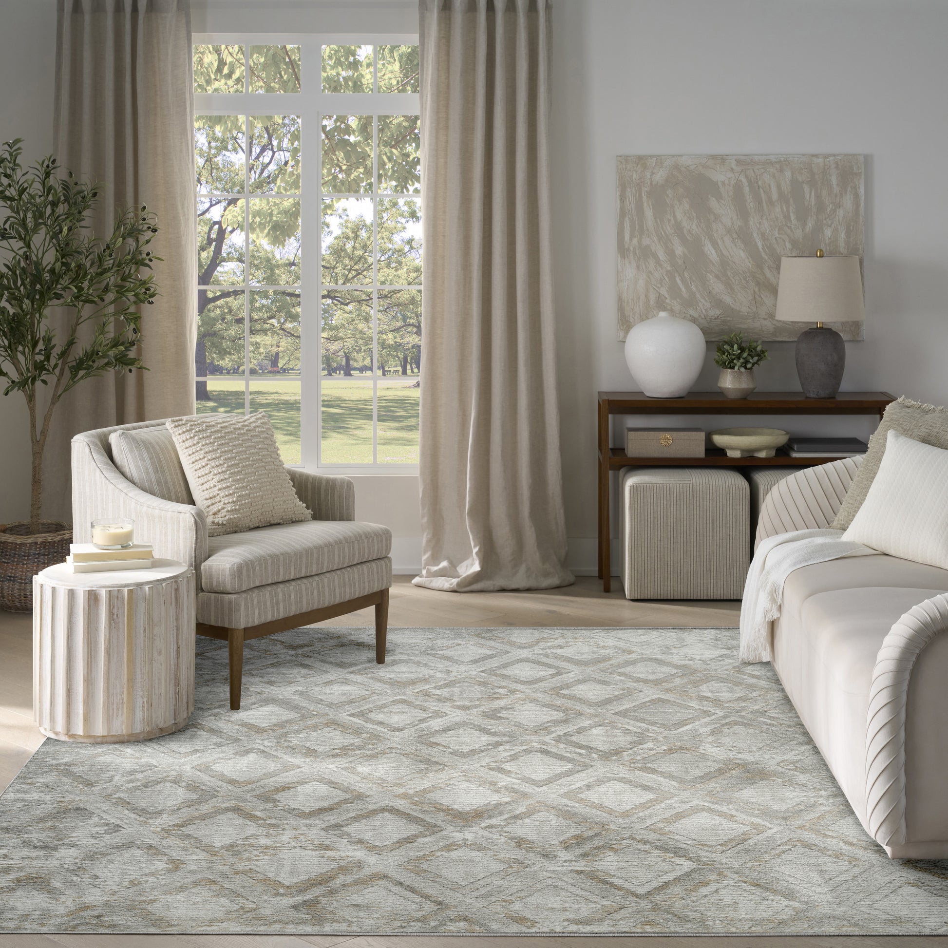 Neutral living room with striped beige armchair, round ribbed side table, beige curtains, and a gray patterned rug.