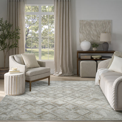 Neutral living room with striped beige armchair, round ribbed side table, beige curtains, and a gray patterned rug.