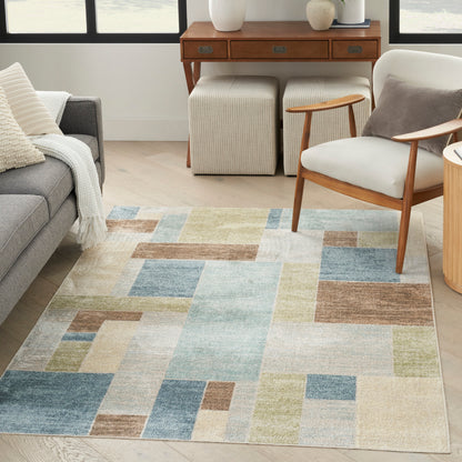 Geometric pastel area rug with blue, beige, green and brown blocks in a modern living room.