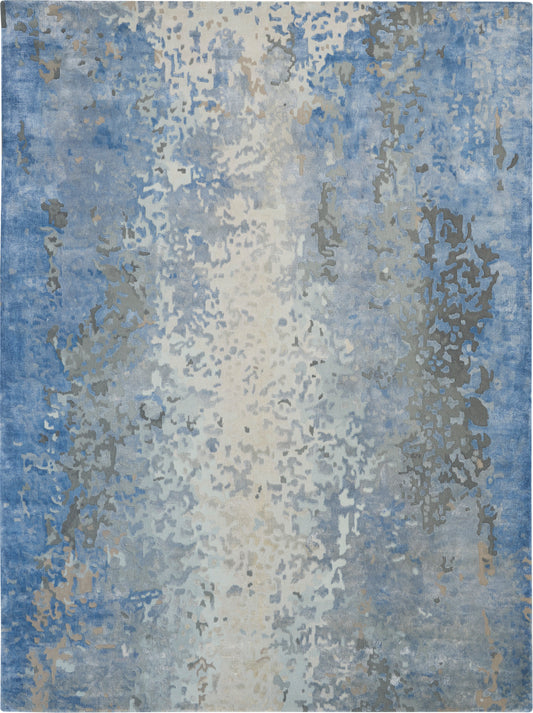 Abstract blue area rug with ivory center and gray speckles; modern, watercolor-like pattern for living spaces.