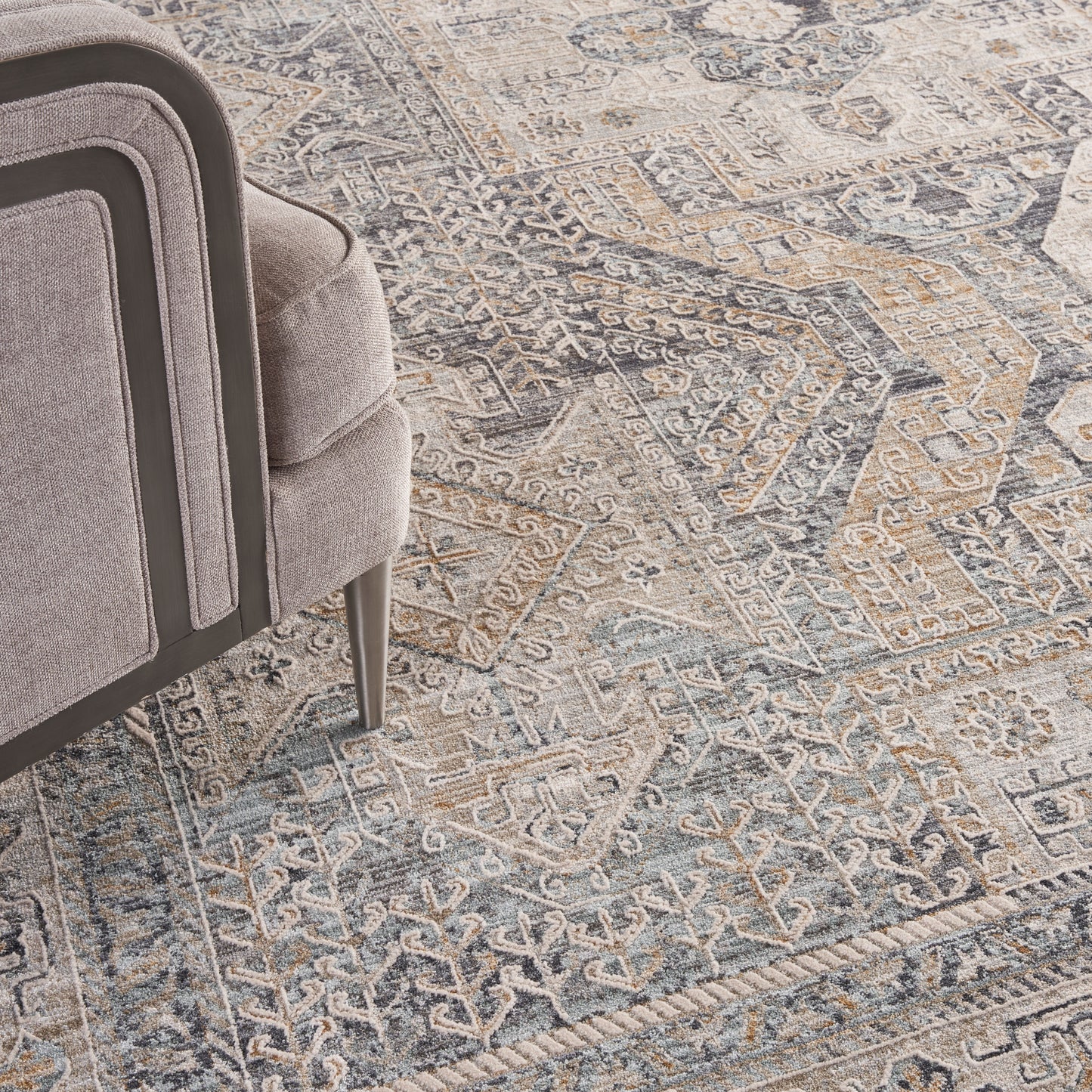 Gray distressed oriental rug in blue and beige tones with a geometric floral pattern.