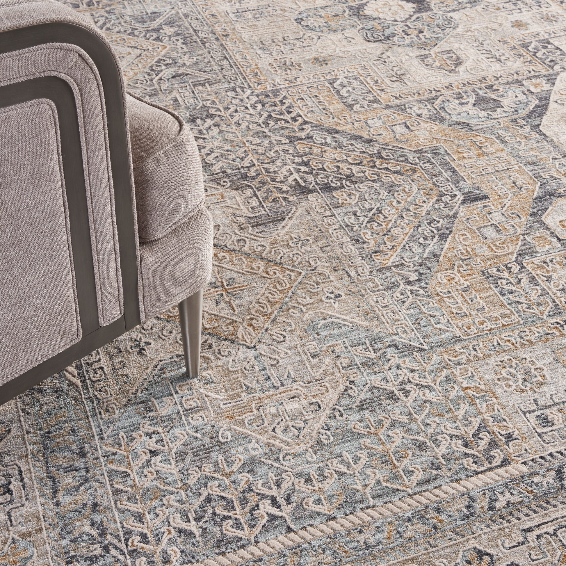 Gray distressed oriental rug in blue and beige tones with a geometric floral pattern.