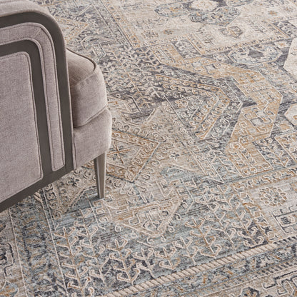 Gray distressed oriental rug in blue and beige tones with a geometric floral pattern.