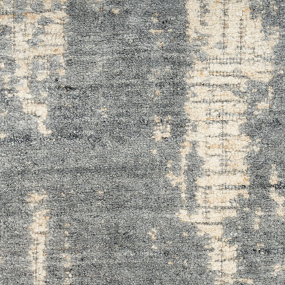 Abstract gray and cream rug with distressed woven texture; blue-gray tones with beige accents.