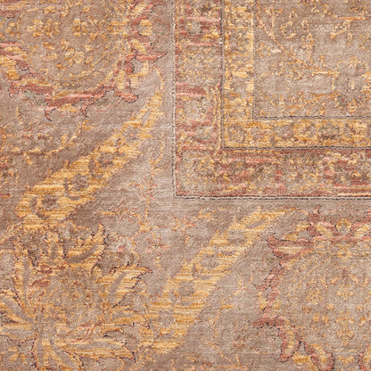 Close-up of a vintage-style oriental rug with gold and pink floral motifs on taupe base and ornate border.