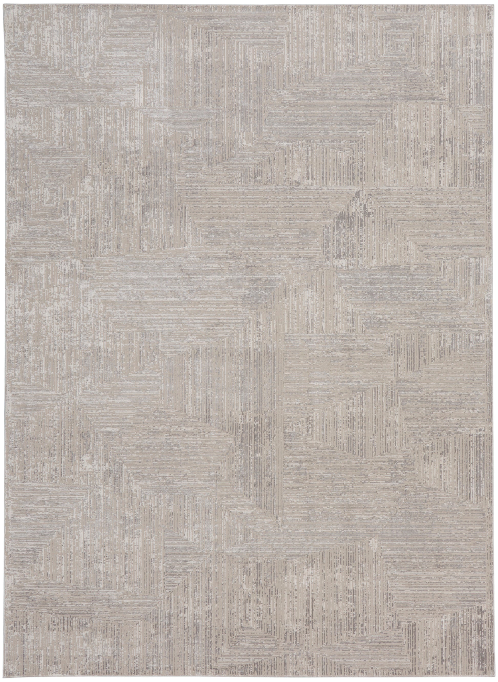 Rectangular beige area rug with cream-toned geometric patchwork and subtle linear textures.