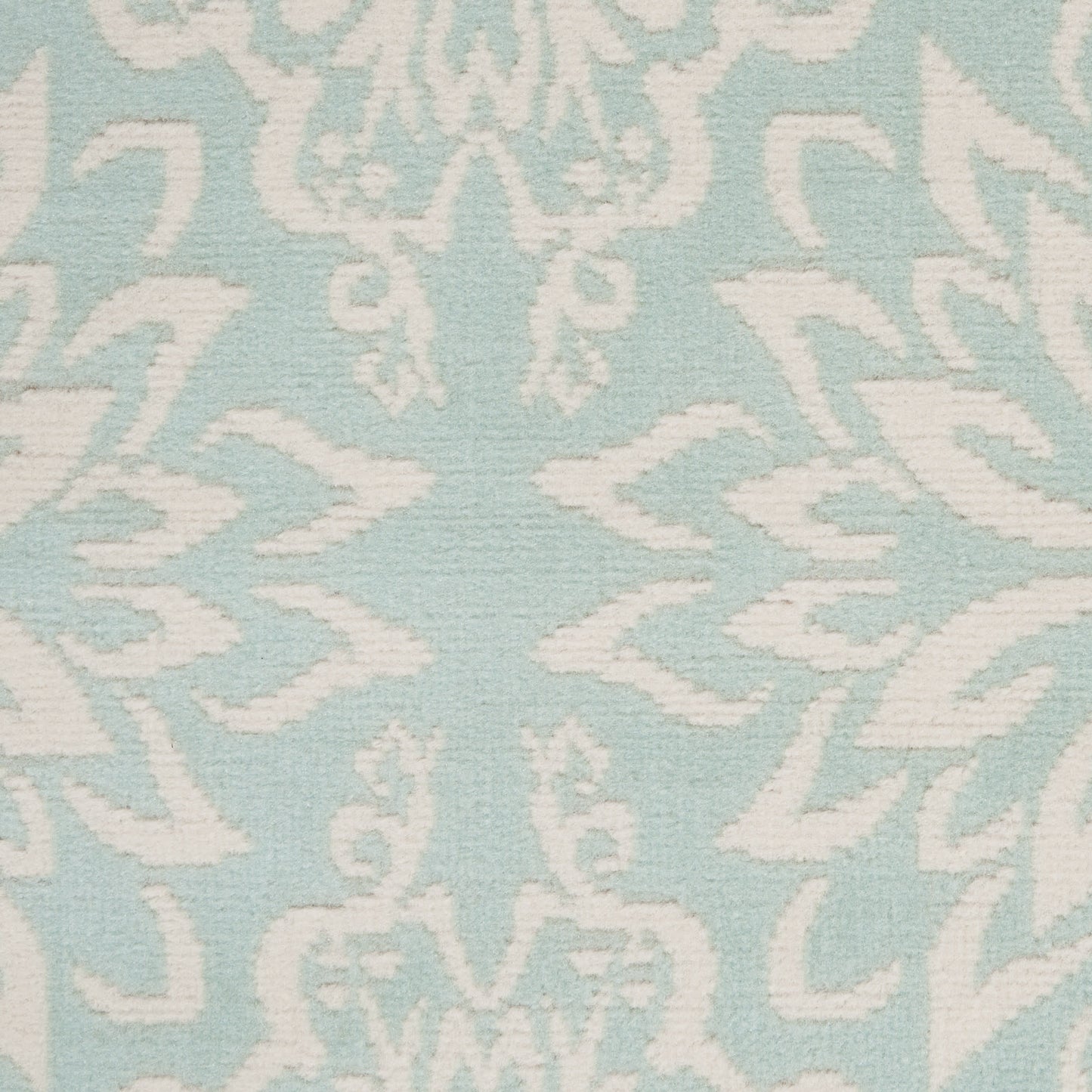 Light blue rug with a white damask floral scroll pattern; 4' x 6'.