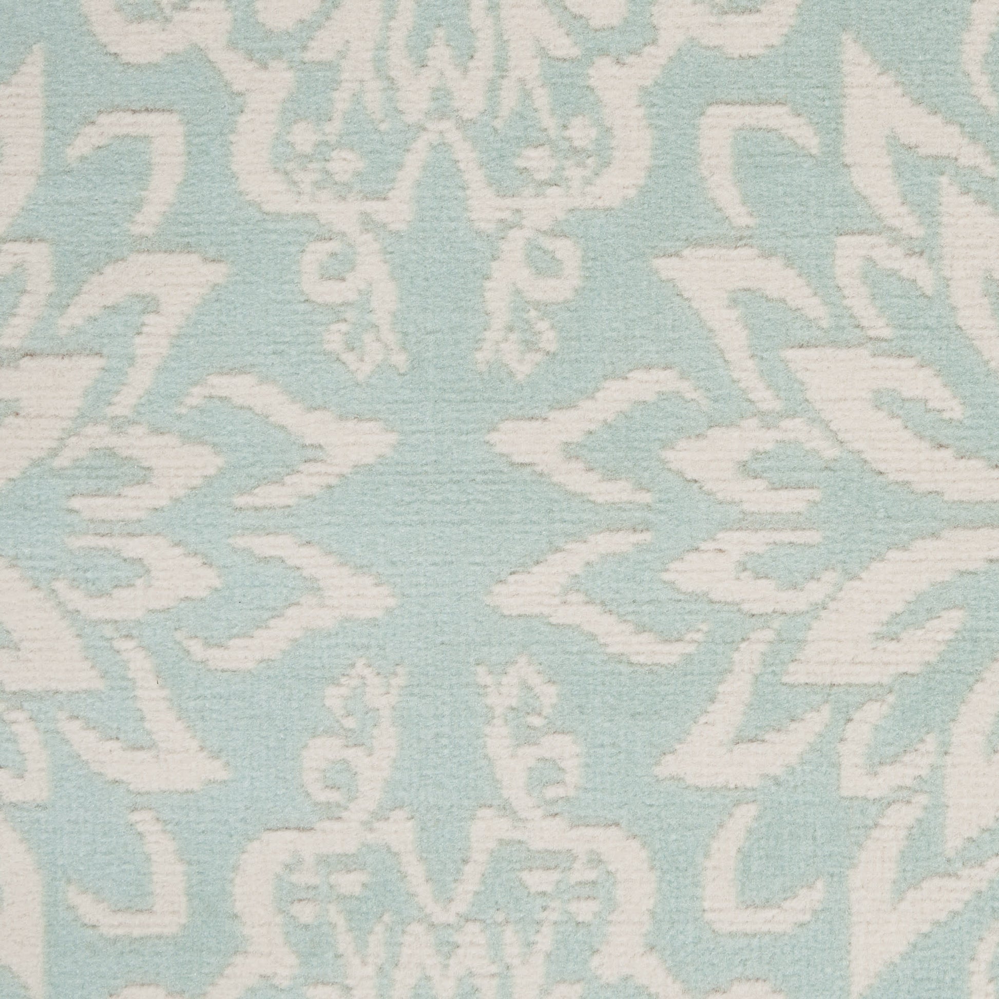 Light blue rug with a white damask floral scroll pattern; 4' x 6'.