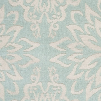 Light blue rug with a white damask floral scroll pattern; 4' x 6'.