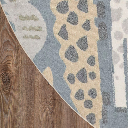 Blue and beige round area rug (8' round) with a grey spotted abstract pattern on dark hardwood floor.