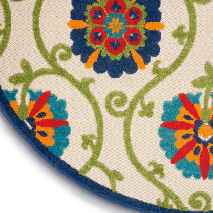 Round decorative rug with vivid multicolor floral medallions and green scrolling vines on beige, navy border.