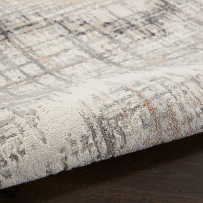 Cream, gray and taupe geometric rug with plush pile and exposed edge.