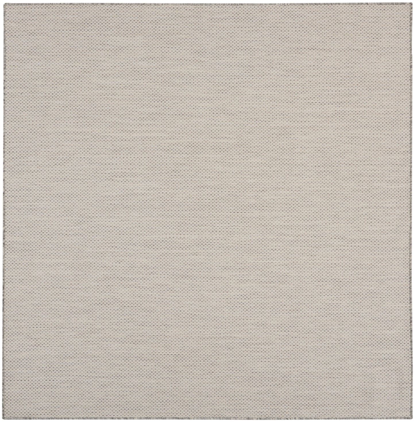 Beige perforated fabric texture with tiny evenly spaced dots; close-up rug pattern.