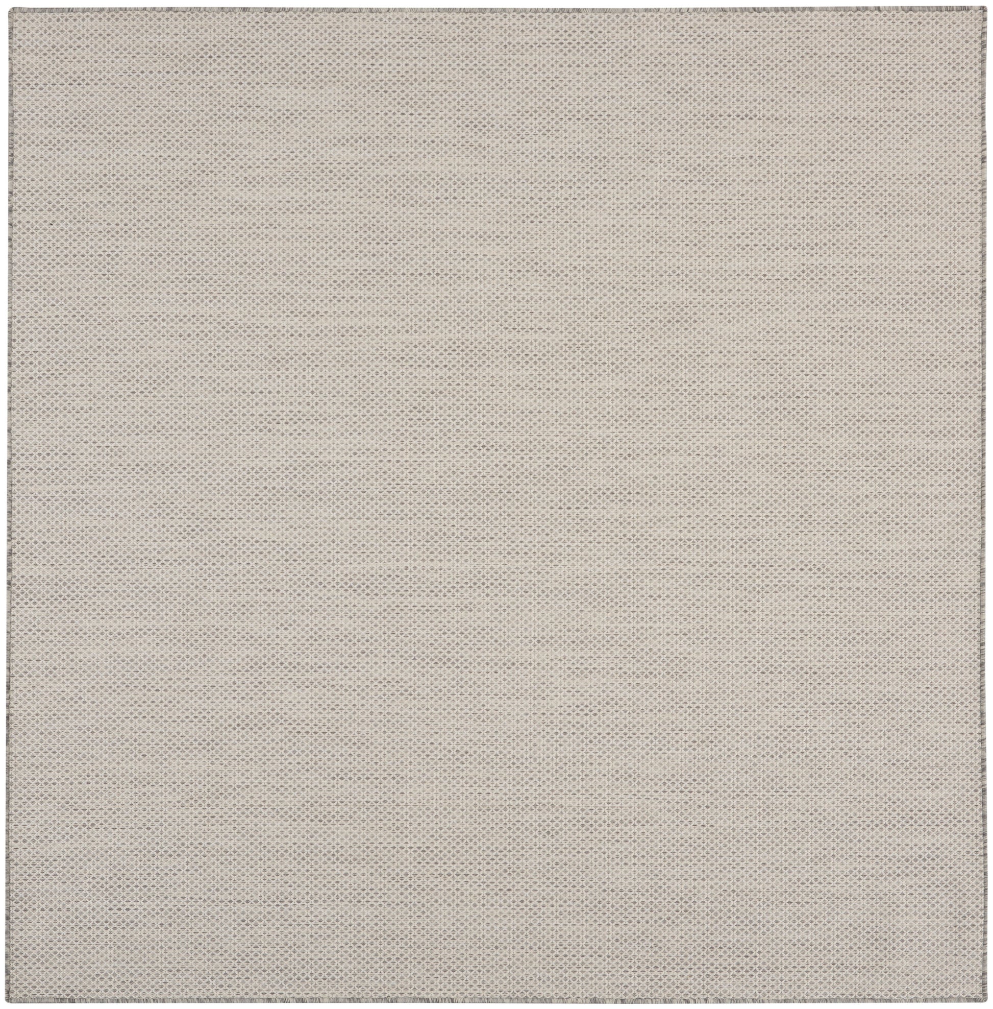 Beige perforated fabric texture with tiny evenly spaced dots; close-up rug pattern.