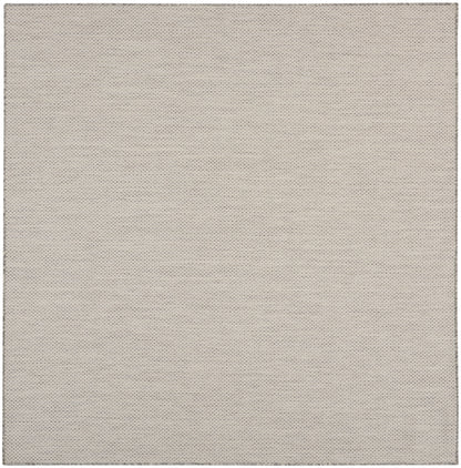 Beige perforated fabric texture with tiny evenly spaced dots; close-up rug pattern.