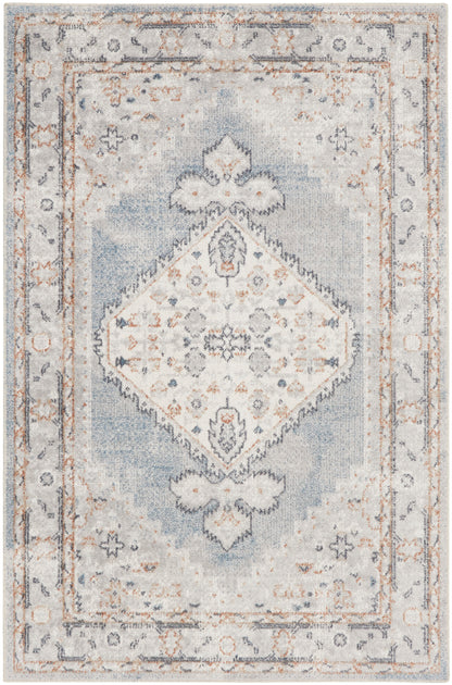 Rectangular vintage-inspired area rug in pale blue and ivory with a central diamond medallion and distressed border