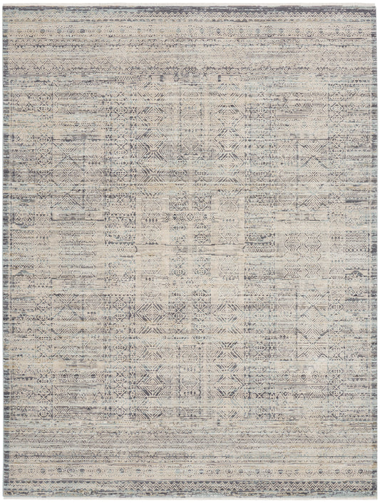 Aztec-inspired geometric area rug in blue-gray and ivory with distressed pattern and bordered edges.