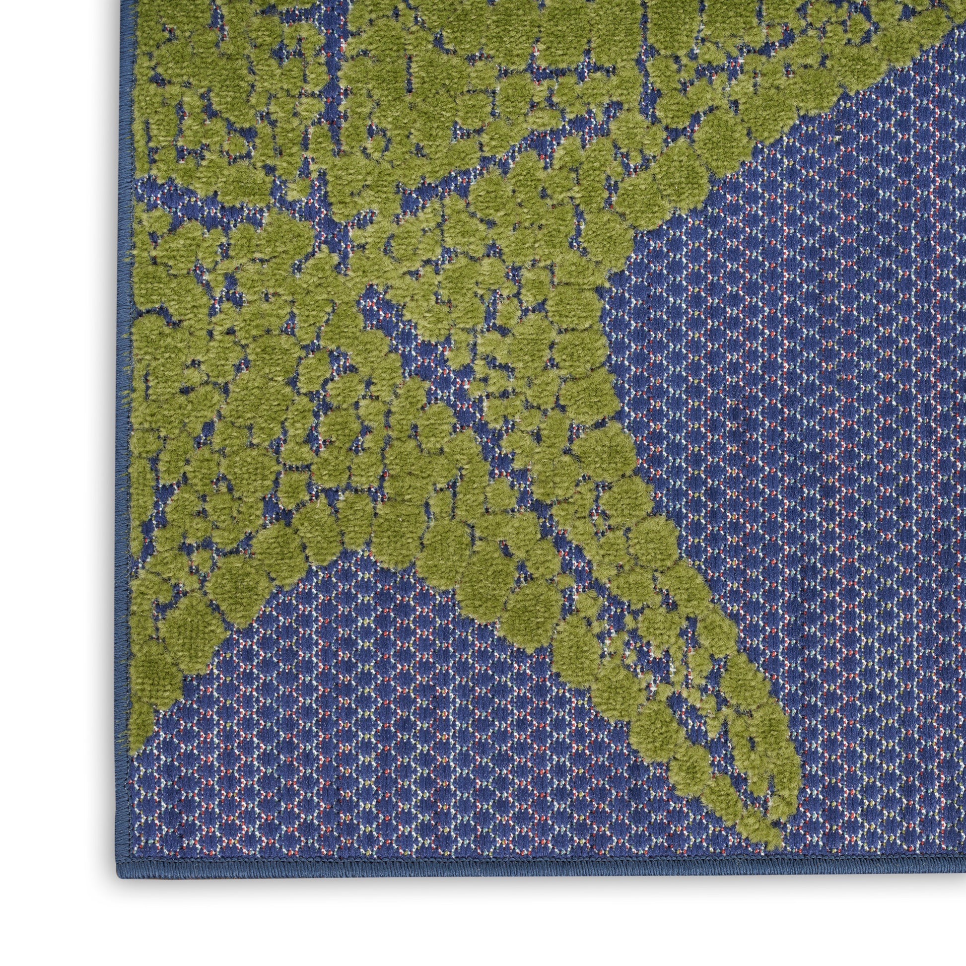 Blue woven outdoor 8' runner rug with olive-green leaf motif, textured raised pattern, blue border.