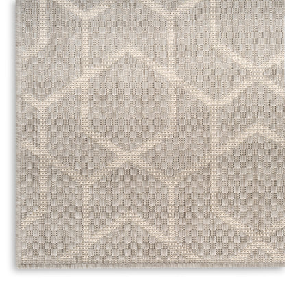 Beige geometric patterned rug with textured diamond motifs; woven, neutral tones for modern decor.