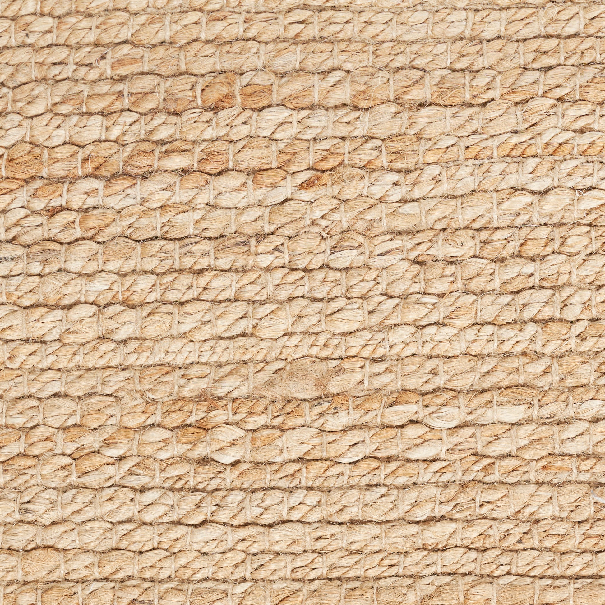 Beige natural fiber woven texture with small circular pattern; resembles a rug or mat.