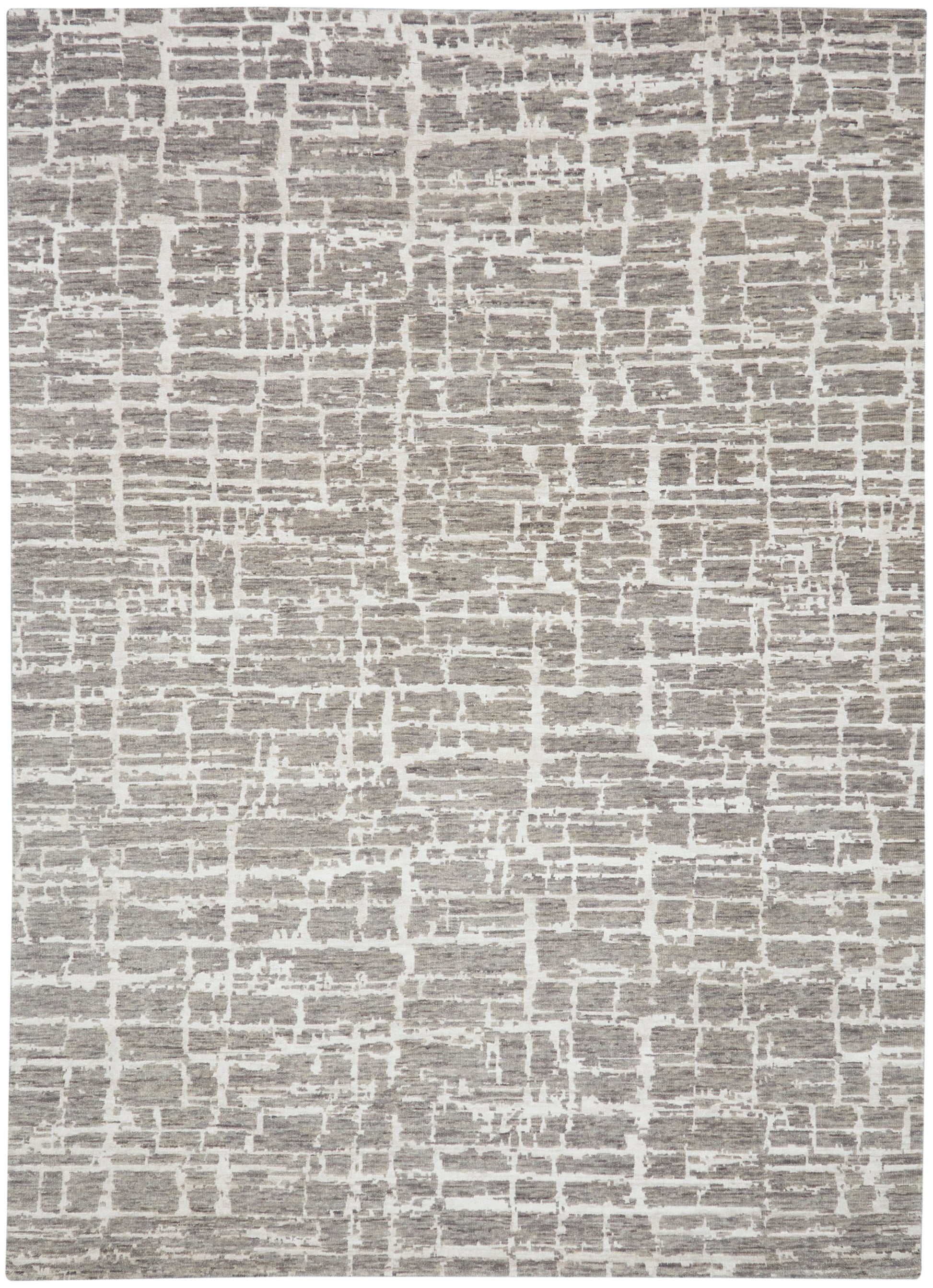 Beige-gray abstract patterned rug with brick-like blocks and soft woven texture.