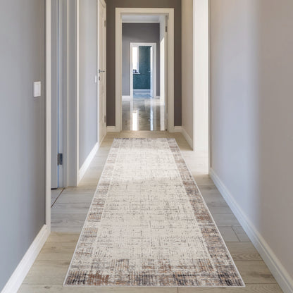Long gray-walled hallway with white trim, light wood flooring, and a beige distressed runner rug.