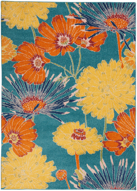 Rectangular woven area rug with teal background and large yellow and orange flowers in a tropical floral print.