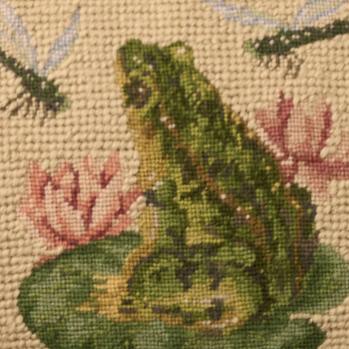 Tapestry textile with a green frog on a lily pad among pink flowers, beige woven background; rustic home decor.