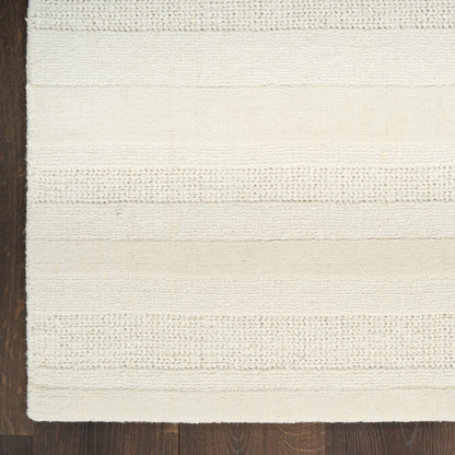 Cream woven rug with horizontal textured stripes on dark wood floor.
