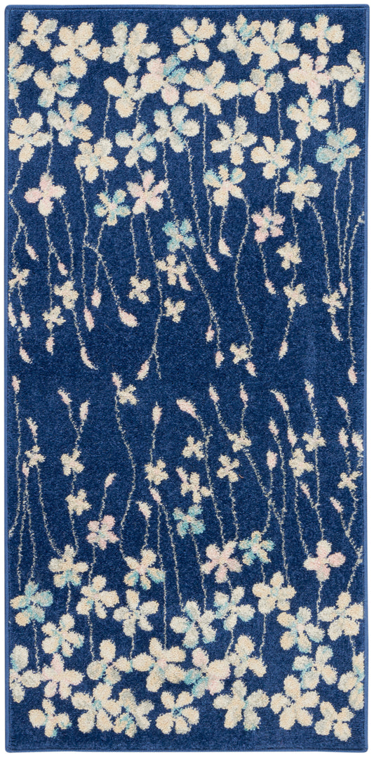 Blue rectangular area rug with white and pastel pink-blue flowers and winding stems.