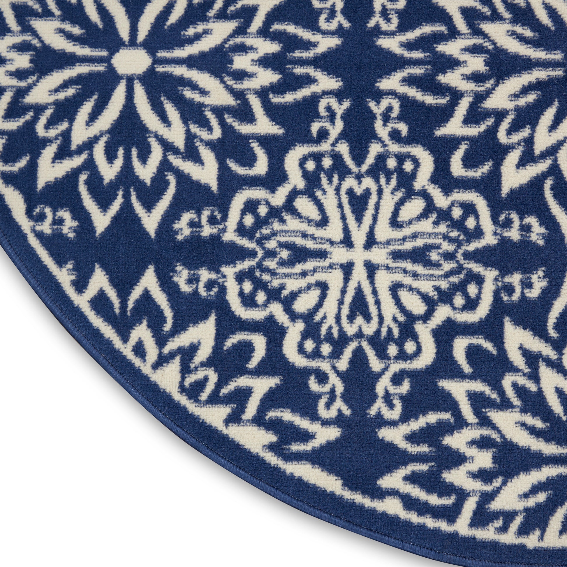 Navy blue circular rug with white intricate mandala patterns and a narrow blue border.