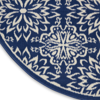 Navy blue circular rug with white intricate mandala patterns and a narrow blue border.