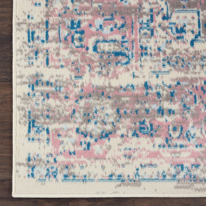 Abstract distressed rug with pink, blue and gray tones on cream background; woven texture with fringe edge.