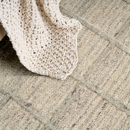 Cream textured rug with subtle geometric lines.